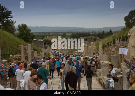 Touristen auf dem antiken Marmor gepflasterte Straße umgeben von Säulen und malerischen Blick auf die Website von Ephesus, Türkei. Stockfoto