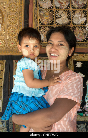 Burmesische Mutter und Kind, Mandalay, Birma. Myanmar. Kind mit bemaltem Gesicht - Thanaka deutlich birmanischen. Stockfoto