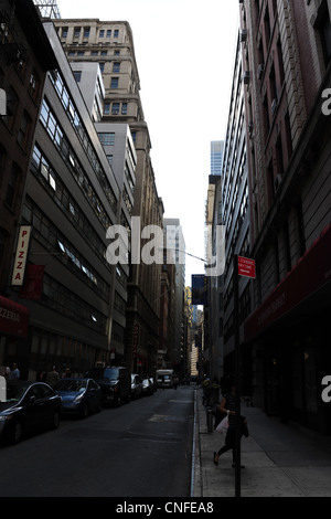 Dunkle Schatten "urban Alley" Porträt geparkten Autos, Passanten, mehrstöckige Gebäude, William Street, Lower Manhattan, New York Stockfoto