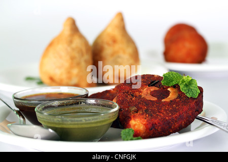 Indische tief gebraten Snack Schnitzel gemacht von Kartoffeln, Masala und Cashew mit Chutneys und ein weiterer beliebter Snack samosa Stockfoto