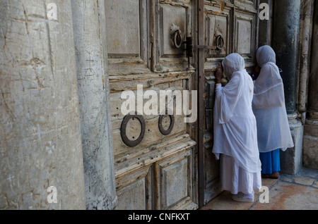 Zwei äthiopischen Frauen beten vor dem geschlossenen Tor des Heiligen Grabes. Altstadt von Jerusalem. Israel. Stockfoto