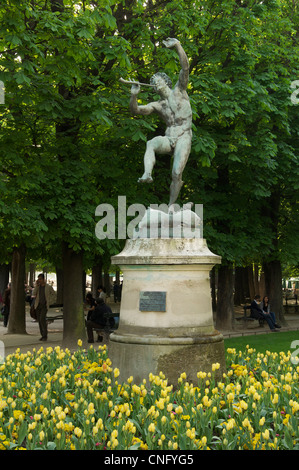 Die Bronze-Statue eines tanzenden Fauns von Eugène-Louis Lequesneist, umgeben von einem Bett von gelben Tulpen im Jardin du Luxembourg. Paris, Frankreich. Stockfoto