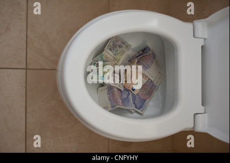 Finanzkrise zeigt Cash hinunter eine Toilette Stockfoto