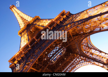 Paris Wahrzeichen. Blick nach oben auf den prächtigen Eiffelturm, das Wahrzeichen von Paris, Flutlicht gegen einen blauen Dämmerung Himmel. Frankreich. Stockfoto