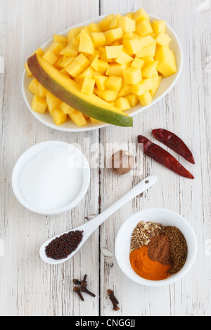 Eine Auflistung von Zutaten wie Mango Scheiben, Zucker und verschiedene Gewürze. Stockfoto