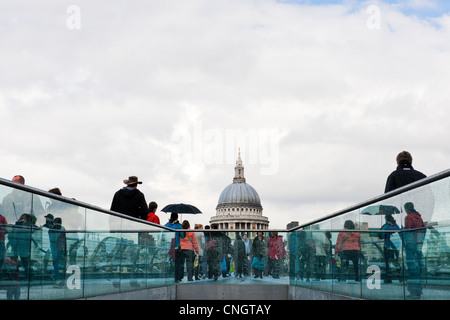 South Bank London Frühjahr nach einem Regenschauer. Menschen, die der Millennium-Brücke in Richtung St Pauls Cathedral Stockfoto
