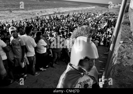 Eine junge katholische Anhänger führt einen römischen Soldaten während der jährlichen Heilige Woche Ritual in Santa Elena, Ecuador. Stockfoto