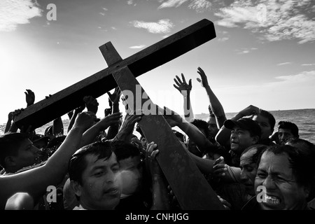 Katholischen Anhänger tragen das Holzkreuz im Meer während des jährlichen Rituals der Karwoche in Santa Elena, Ecuador. Stockfoto