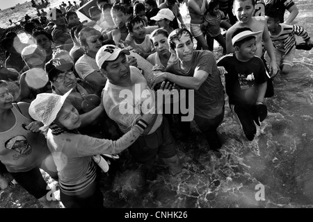 Katholischen Anhänger tragen das Holzkreuz im Meer während des jährlichen Rituals der Karwoche in Santa Elena, Ecuador. Stockfoto