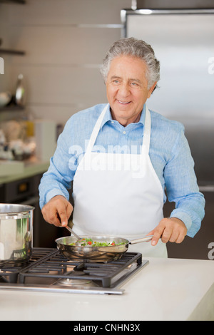 Einen fröhlichen zog Man Gemüse in einer Pfanne Kochen Stockfoto