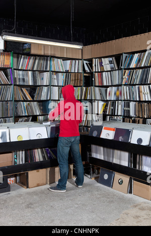 Ein junger Mann auf der Suche durch Datensätze in einem Plattenladen, Rückansicht Stockfoto