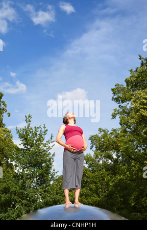Eine schwangere Frau im Natur in der Sonne aalen Stockfoto