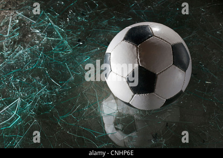 Ein Fußball auf Glasscherben Stockfoto
