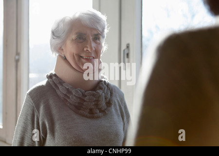 Eine lächelnde senior Frau tragen einer Halskrause Stockfoto