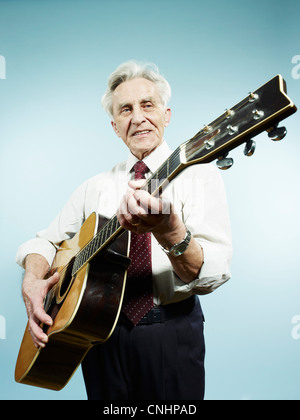 Ein senior Mann spielt eine akustische Gitarre Stockfoto