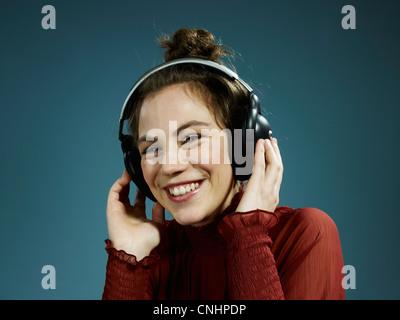 Eine junge hip Frau tragen von Kopfhörern und lächelnd Stockfoto