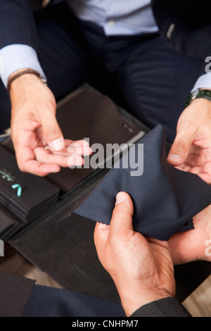 Detail der beiden Männer halten Stoffmuster Stockfoto