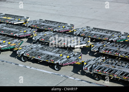 Leere Gepäck Anhänger auf einem Flughafen-Asphalt Stockfoto