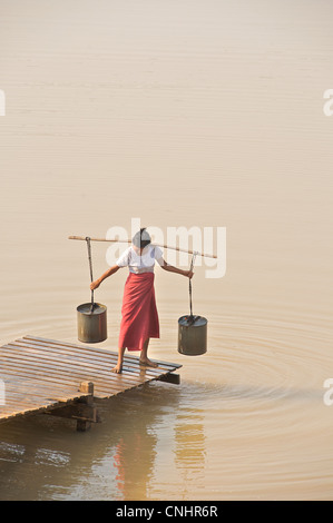 Burmesische Frau sammeln von Wasser aus einem Reservoir zwischen Mount Popa und Bagan Myanmar. Myanmar. Wasser-Festival-Vorbereitungen Stockfoto
