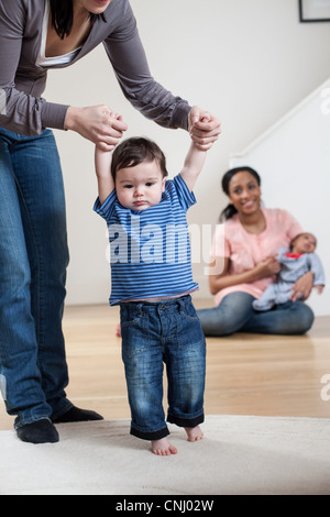 Mutter hilft Sohn zu Fuß Stockfoto