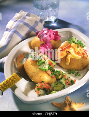 Kartoffeln gefüllt mit Heringssalat und Krabbensalat Stockfoto