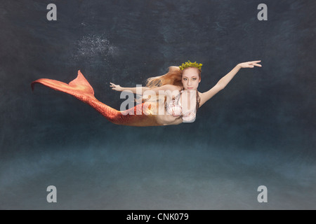 Meerjungfrau Schwimmen unter Wasser mit einer Seetang-Krone Stockfoto