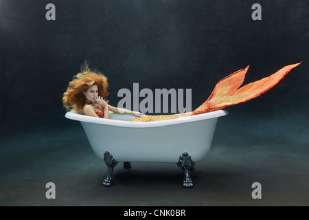 Junge Meerjungfrau Faulenzen unter Wasser in ihrem Victoria + Albert Badewanne Stockfoto