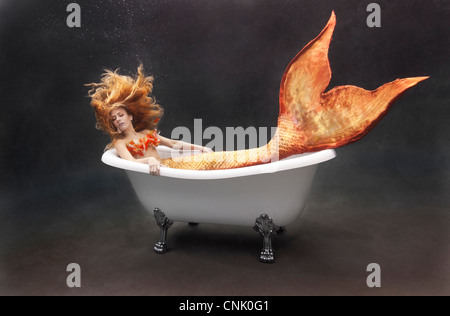Junge Meerjungfrau Faulenzen unter Wasser in ihrem Victoria + Albert Badewanne Stockfoto