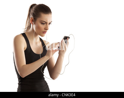 Schöne junge Frau, die Verfolgung ihrer Kalorien nach dem Sport mit ihrem iPhone 4 Stockfoto