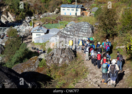 Eine Schar von Wanderern übergibt eine Mani-Mauer auf dem Weg zum Everest-Basislager Stockfoto