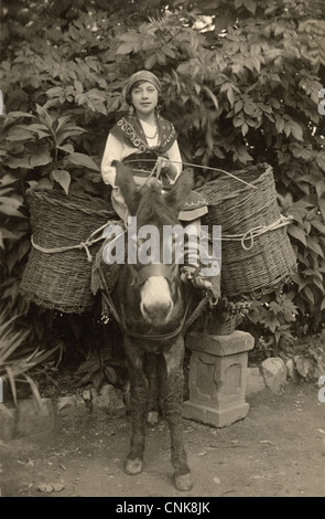 Junge Zigeunerin mit Korb beladene Esel Stockfoto