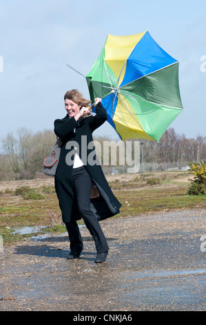 Frau, die kämpfen, um ihren Schirm bei starkem Wind halten Stockfoto