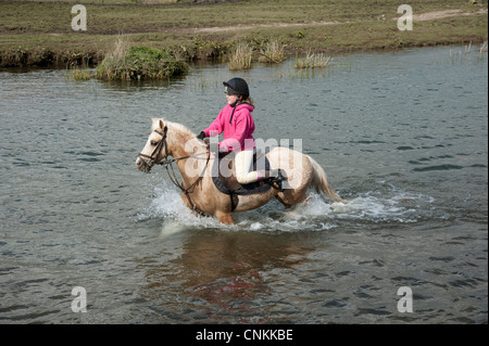 Pony Reiter überqueren den Fluss Ewenny an Ogmore in Vale von Glamorgan S Wales Großbritannien Stockfoto