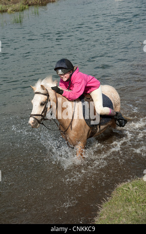 Pony Reiter überqueren den Fluss Ewenny an Ogmore in Vale von Glamorgan S Wales Großbritannien Stockfoto