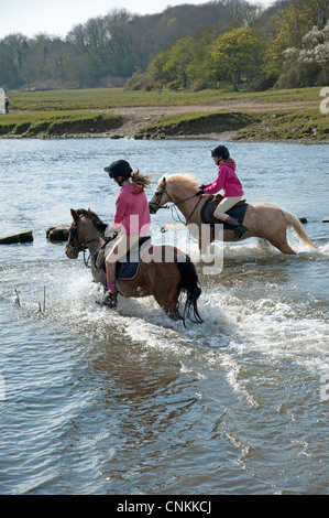 Pony Reiter überqueren den Fluss Ewenny an Ogmore in Vale von Glamorgan S Wales Großbritannien Stockfoto