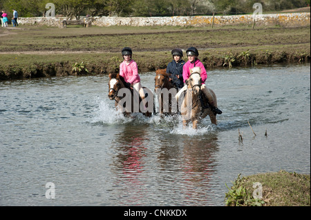 Pony Reiter überqueren den Fluss Ewenny an Ogmore in Vale von Glamorgan S Wales Großbritannien Stockfoto