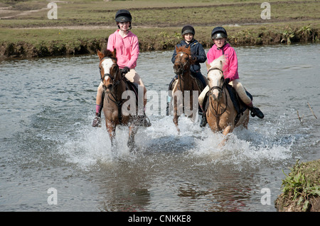 Pony Reiter überqueren den Fluss Ewenny an Ogmore in Vale von Glamorgan S Wales Großbritannien Stockfoto