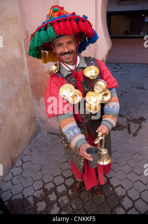 Die traditionelle Uniform und den spektakulären bunten Hut eines marokkanischen Wasser-Verkäufer in den Straßen von Marrakesch in Marokko Stockfoto