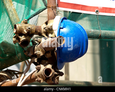 Arbeitnehmer-Helm auf dem Gerüst während dem Mittagessen Breake hängen Stockfoto