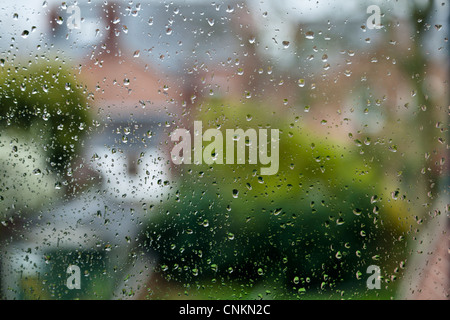 Regentag. Regentropfen auf ein Fenster mit der Entfernung unscharf, England, Großbritannien Stockfoto