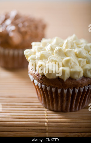 Lecker aussehende Schokolade Cupcake mit Vanille Zuckerguss auf Bambus Tischset-flacher Fokus Stockfoto