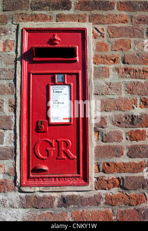 Ein traditionelle rote Royal Mail-Briefkasten aus der Regierungszeit von König George VI in eine alte Mauer gesetzt Stockfoto