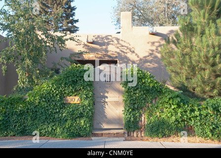 Efeu an einem bewachten Eingang bringt Farbe in den Vordergrund dieser Residenz in Santa Fe. Stockfoto