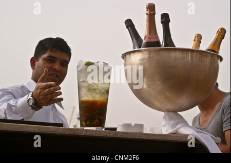 Barkeeper mit einem Cocktail und Flaschen Veuve Clicquot Champagner im Park Hyatt Hotel, Dubai Creek, Dubai, Vereinigte Arabische Emirate Stockfoto