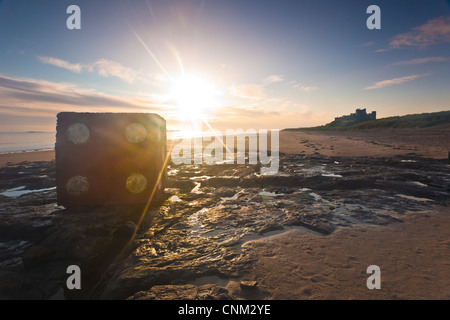 Einer der ww11 Betonpanzerblöcke, die als riesige rote Würfel am Strand vor Bamburgh Castle an der Northumberland Coast gemalt wurden Stockfoto