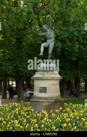 Die Bronze-Statue eines tanzenden Fauns von Eugène-Louis Lequesneist, umgeben von einem Bett von gelben Tulpen im Jardin du Luxembourg. Paris, Frankreich. Stockfoto