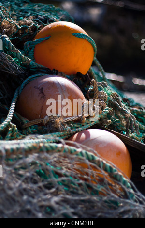 3 Orangen Bojen in Fischernetzen Stockfoto