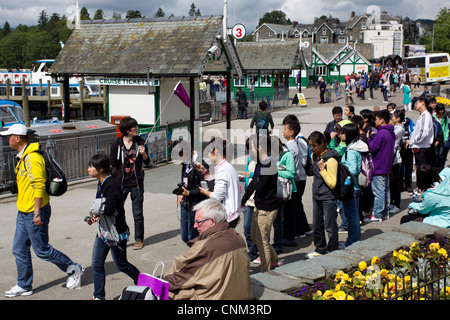 China tour Gruppe von jungen Teenagern die digitalen Fotos von Schwänen und füttern in Bowness Bay am Lake Windermere Stockfoto