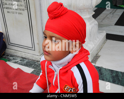 Asien Indien Punjab Amritsar Golden Temple oder Hari Mandir A Kind mit der charakteristischen Kopfbedeckung der Sikhs Stockfoto