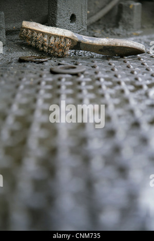 Drahtbürste auf ölig und rostigen Stahl Checker Plattieren. Stockfoto